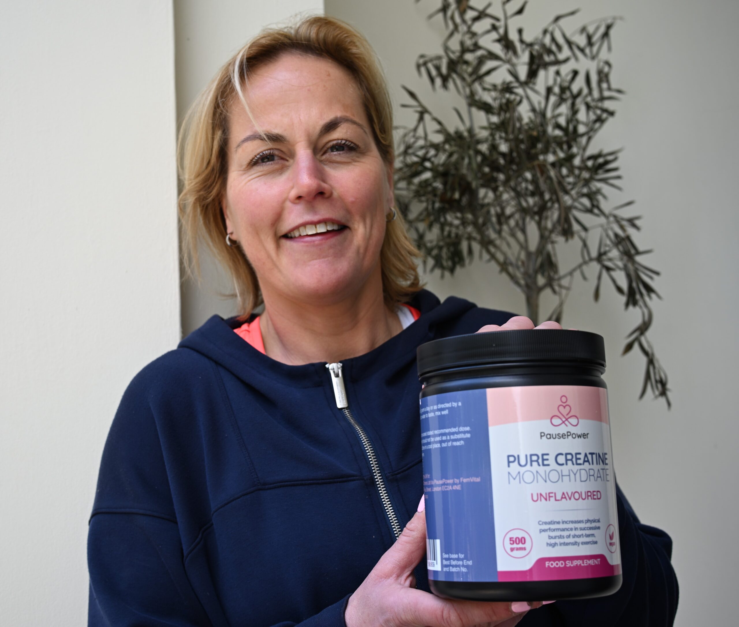 Marleen holding PausePower creatine outdoors for women’s strength and menopause support